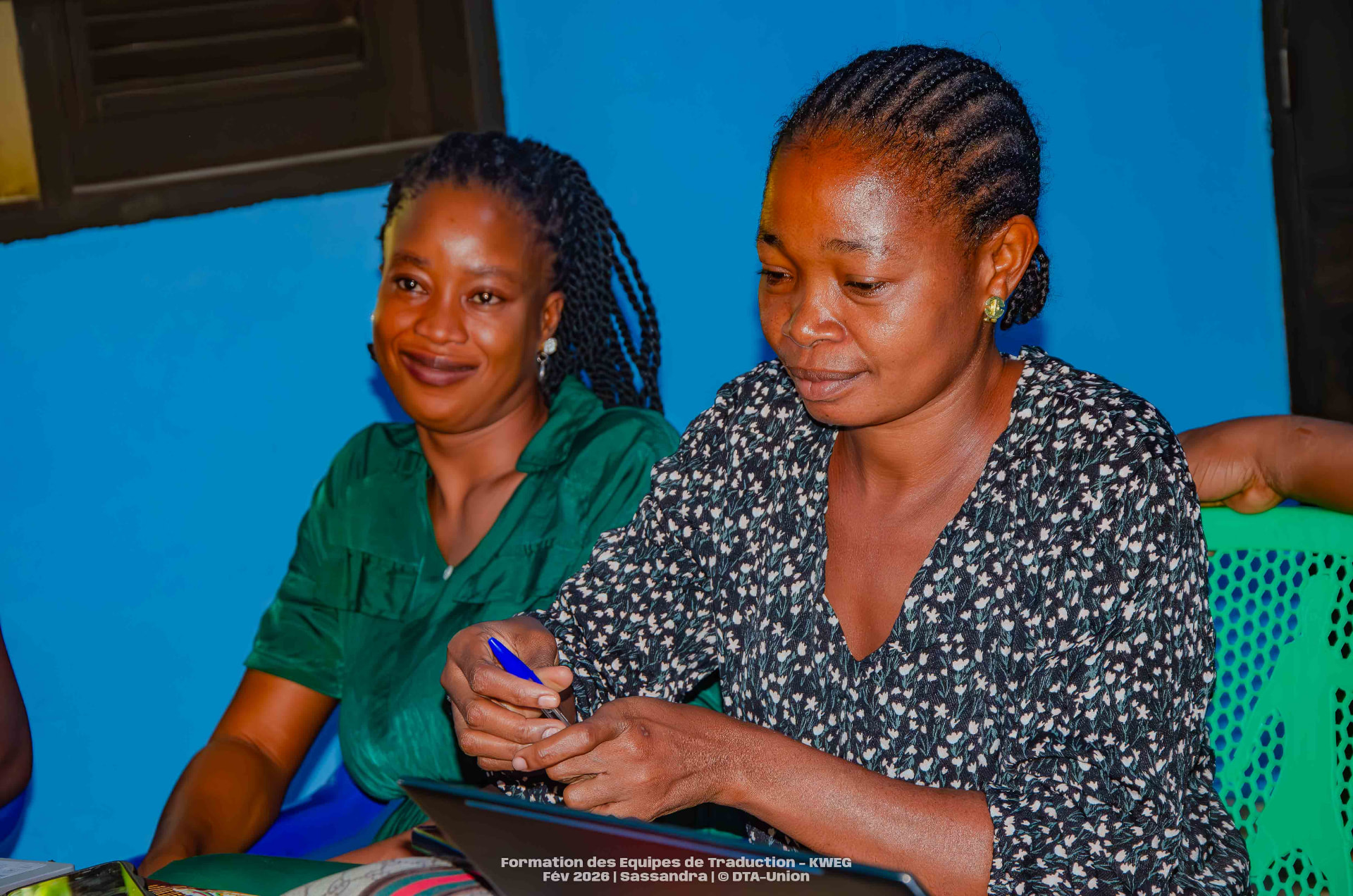 Deux traductrices travaillant ensemble sur une tablette pendant la session de Sassandra
