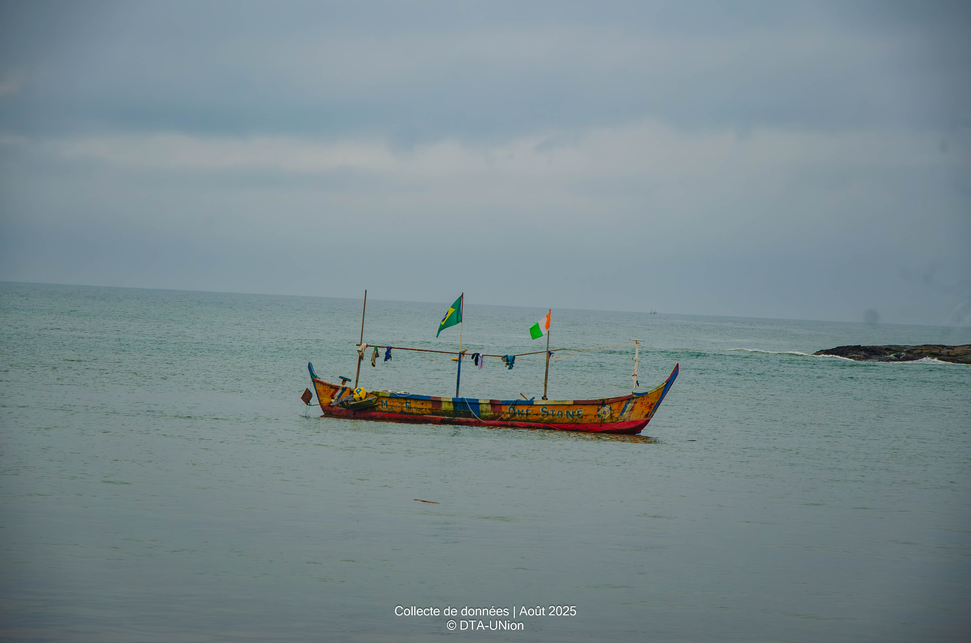 Pirogue de pêche wané au large, drapeaux ivoirien et brésilien hissés